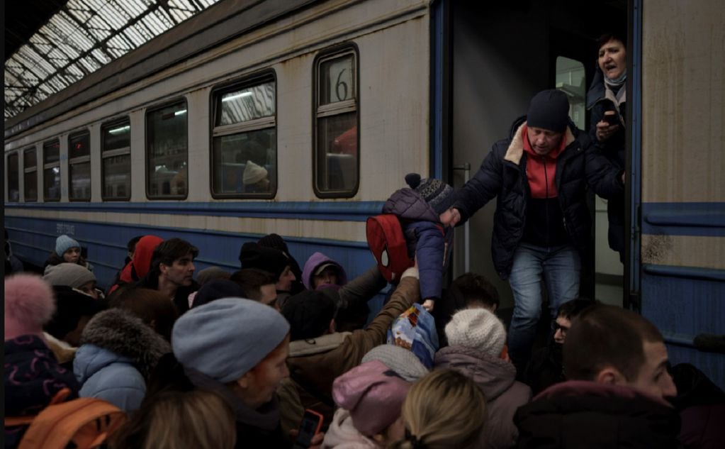 Los pasajeros se apresuran a abordar un tren que parte de la estación de tren de Lviv, al oeste de Ucrania, hacia Eslovaquia. (AP) 