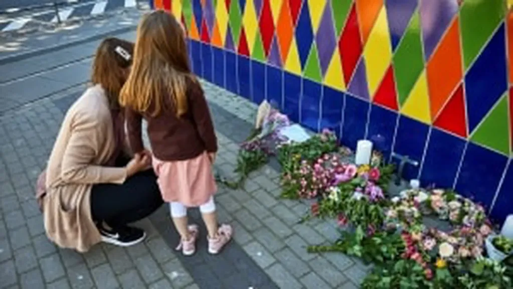 Personas dejan flores por la joven que murió en el parque de diversiones Tivoli, en Dinamarca. Foto: Gentileza