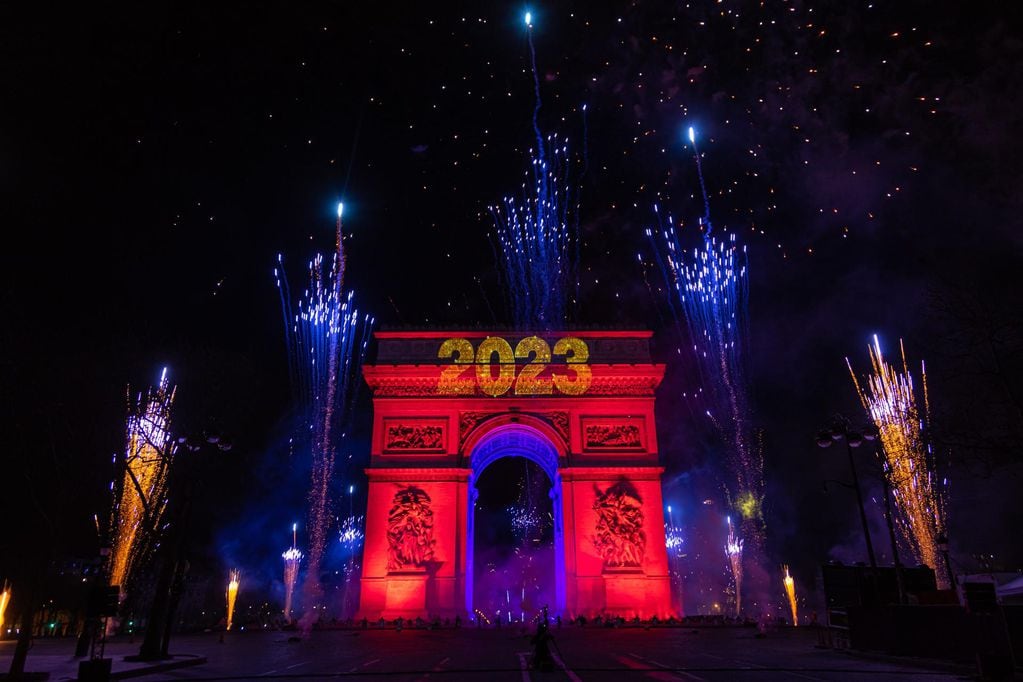 Un espectáculo de luces y fuegos artificiales en el Arco del Triunfo mientras los juerguistas celebran el año nuevo 2023 en la avenida de los Campos Elíseos en París. Foto: EFE/EPA/CHRISTOPHE PETIT TESSON