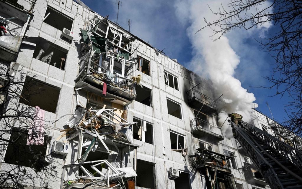 Los bomberos trabajan en un incendio en un edificio después de los bombardeos en la ciudad de Chuguiv, en el este de Ucrania. (AP)