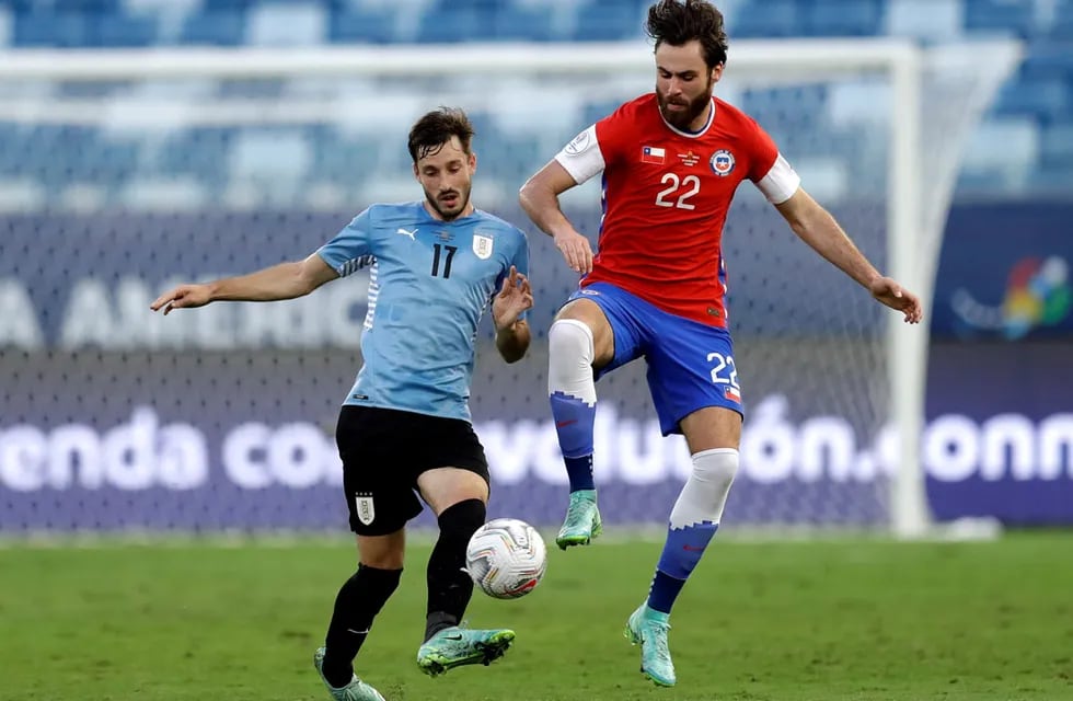 Matías Vina, de Uruguay, disputa la pelota con Ben Brereton, de Chile, en el partido que se jugó en Cuiaba, Brasil, por la Copa América. (AP)