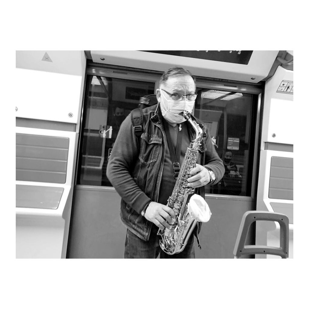 Música sin gente. Un saxofonista adapta su barbijo para tocar dentro de un vagón de subterráneo prácticamente vacío.