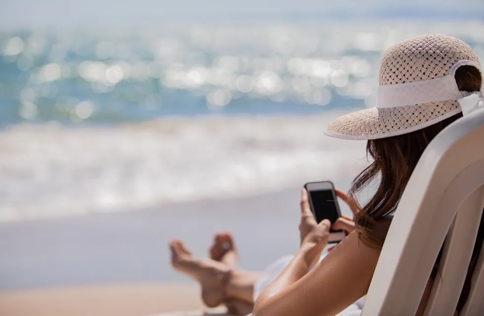 En otra cosa, la mujer frente al mar pero sumergida en su celular.