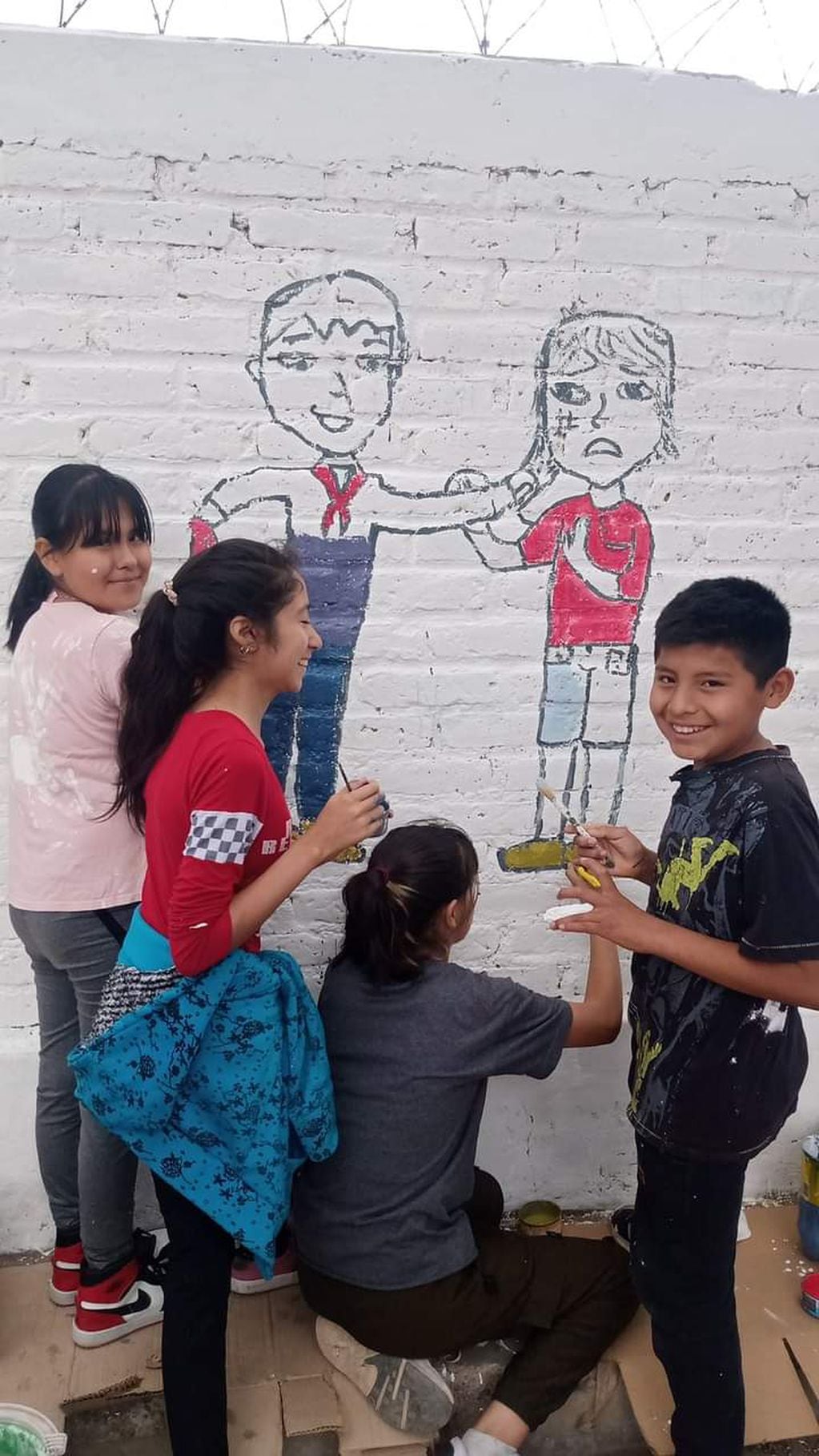 Los chicos de la escuela Tierras Huarpes de Guaymallén, en plena tarea de pintura de un mural contra el acoso escolar.