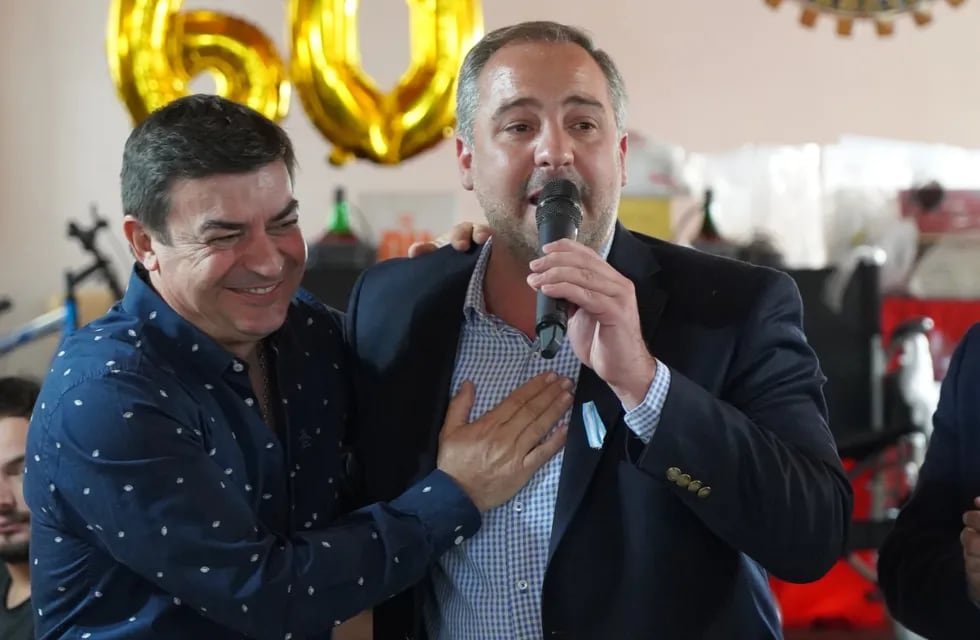 Omar De Marchi y el intendente de Maipú, Matías Stevanato, se abrazan en un acto del Rotary Club de Rodeo del Medio.