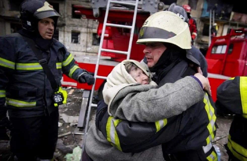 En esta foto publicada por el Servicio Estatal de Emergencias de Ucrania, un bombero abraza a una anciana después de ser evacuada de un edificio de apartamentos afectado por bombardeos en Kiev, Ucrania (AP)