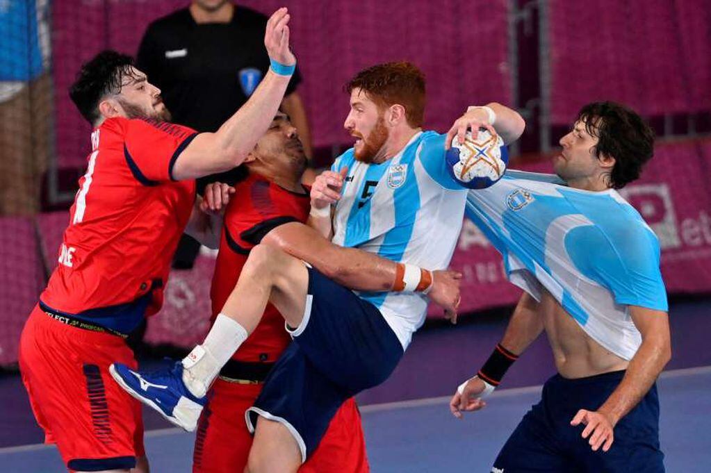 
Foto: AFP | El ala izquierda de Argentina Pablo Vainsteines bloqueado por el pivote de Chile Javier Frelijj durante el partido por la medalla de oro de balonmano masculino.
   