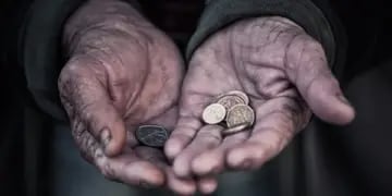 Monedas sobre manos de anciano