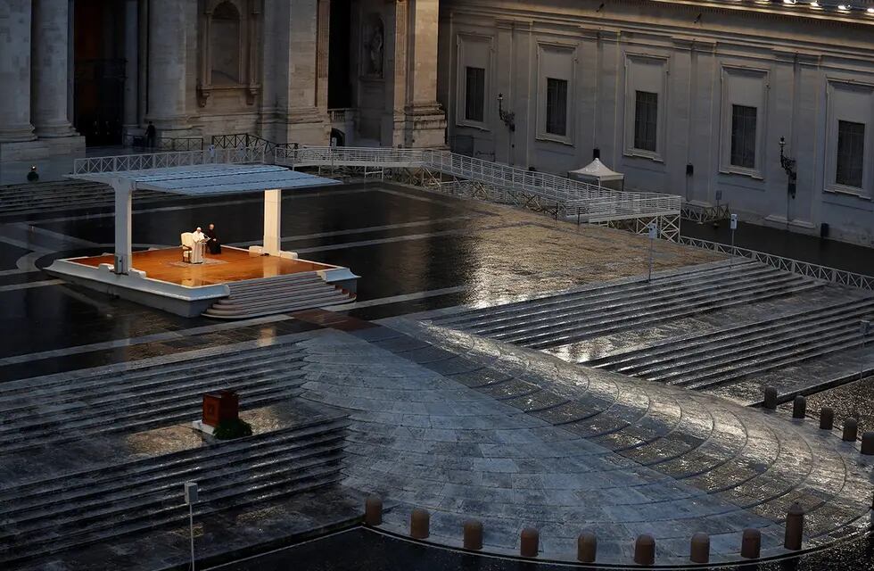 COVID-19. El Papa Francisco, una figura blanca sola en el centro, pronuncia una oración Urbi et orbi desde la Plaza de San Pedro vacía, en el Vaticano, el viernes 27 de marzo de 2020. (AP)