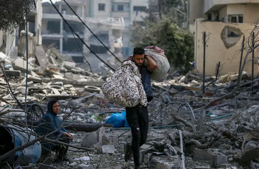 Gaza (---), 10/10/2023.- A Palestinian woman (L) sits among the rubble in the destroyed Al-Ramal neighborhood following an Israeli air strike in Gaza City, 10 October 2023. More than 700 people have been killed and around 4,000 have been injured according to the Palestinian Ministry of Health, after Israel started bombing the Palestinian enclave in response to an attack carried out by the Islamist movement Hamas on 07 October. More than 3,000 people, including 1,500 militants from Hamas, have been killed and thousands injured in Gaza and Israel since 07 October, according to Israeli military sources and Palestinian officials. EFE/EPA/MOHAMMED SABER
