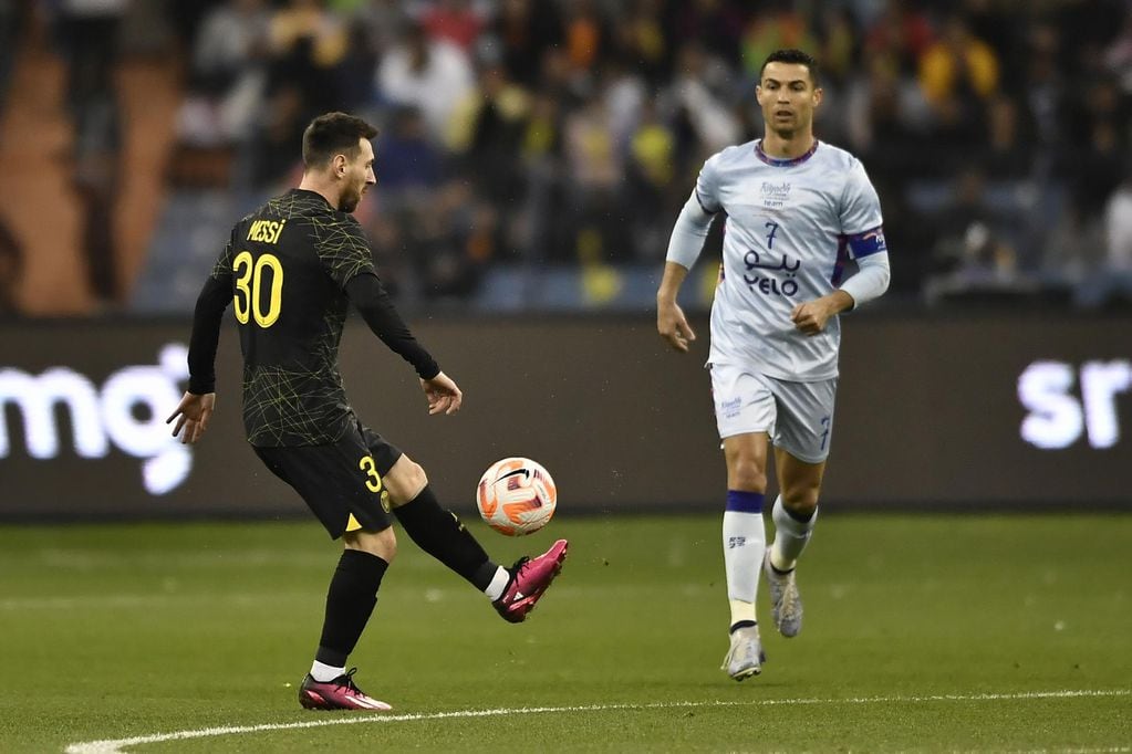 El delantero del PSG Leo Messi disputa el balón con el delantero del Riyadh XI, Cristiano Ronaldo, durante el partido amistoso. EFE