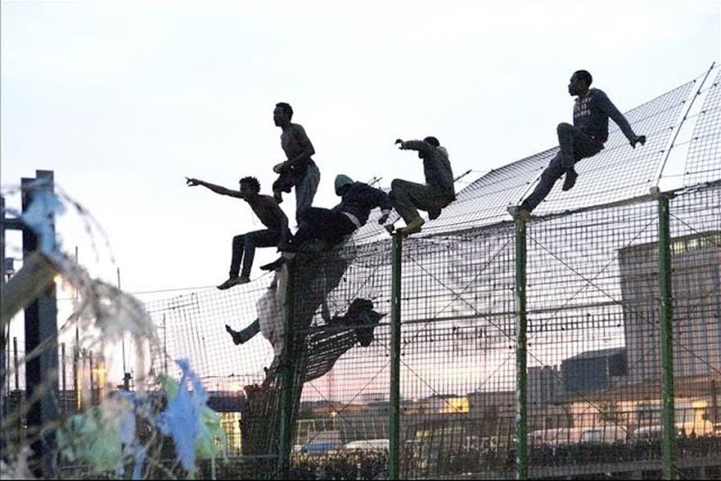 Migrantes saltando la Valla de Melilla, en España