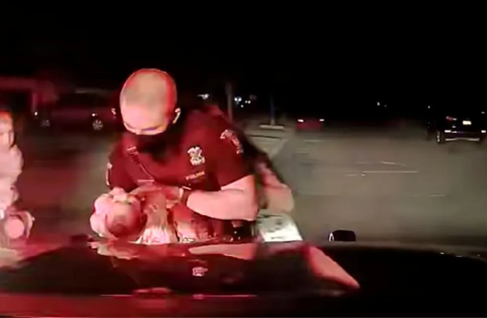 El policía asiste a la bebé.