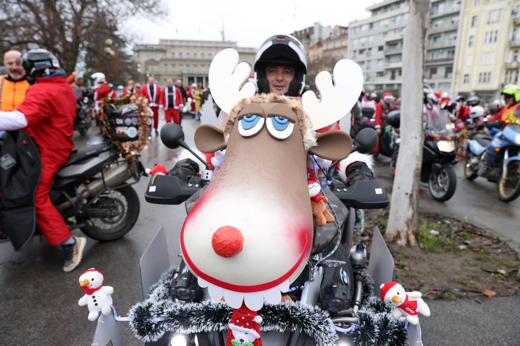 Un motociclista vestido con traje de Papá Noel posa para una foto en Belgrado, Serbia, el 24 de diciembre de 2022. Un grupo de motociclistas se reunió en la capital serbia para un viaje conjunto para llevar regalos de Navidad para niños de escasos recursos. Foto: EFE/ANDREJ CUKIC
