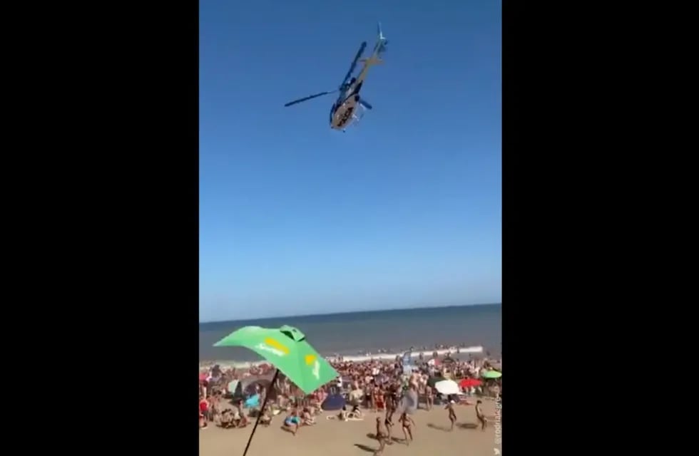 El helicóptero pasó muy cerca de la playa y voló varias sombrillas. / Foto: captura de video