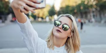 Young woman is taking a selfie by mobile phone.