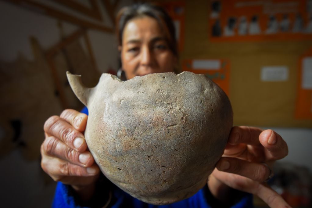 Marisa Mayorga sostiene una antigua pieza de cerámica Huarpe Pueblo San José, a unos 80 kilómetros al Norte de la villa cabecera de Lavalle, y que tiene como escenario central una centenaria capilla de adobes.