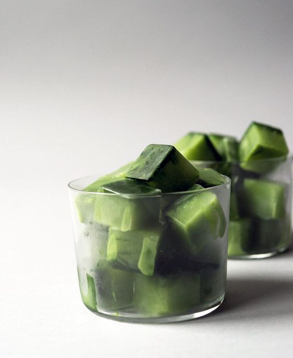 Cubitos de hielo hechos con té verde para aplicar sobre el rostro antes del maquillaje veraniego.