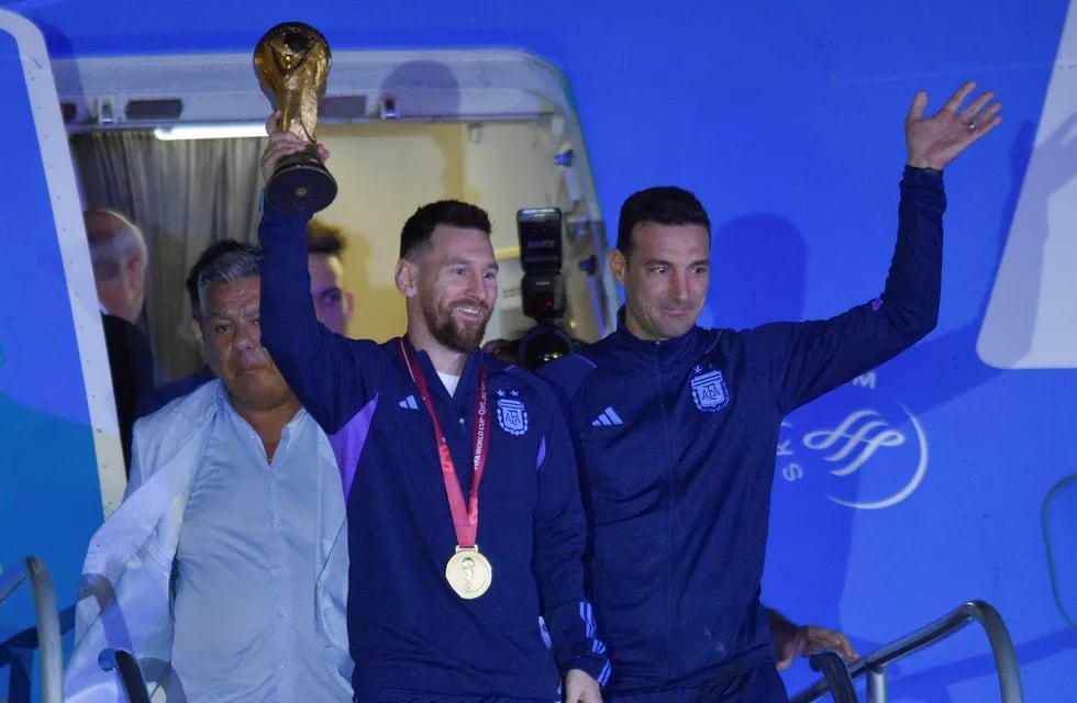 Lionel Messi, con la copa de campeón del mundo, acompañado por el DT Lionel Scaloni.