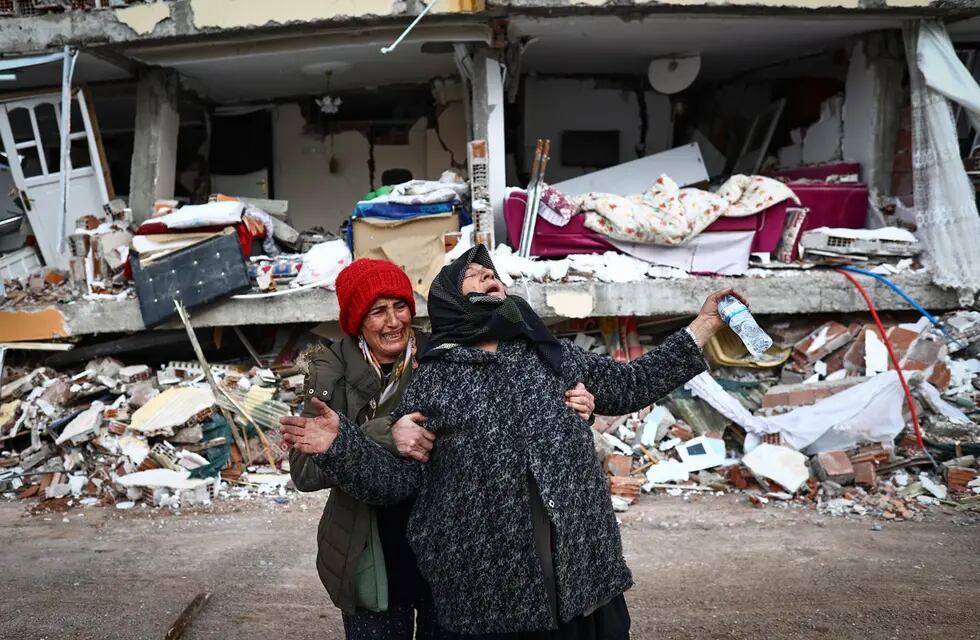 Mujeres reaccionan en el lugar de un edificio derrumbado tras un gran terremoto en el distrito de Elbistan de Kahramanmaras, Turquía (EFE)