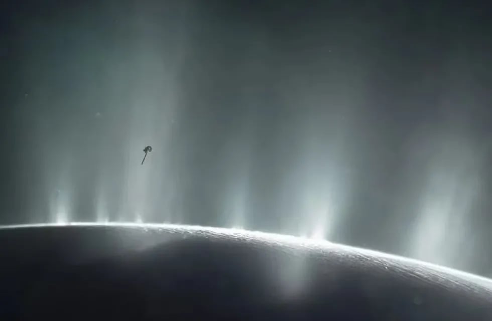 Impresión artística de la nave espacial Cassini volando a través de una columna de supuesta agua que brota de la superficie de Encelado, la luna de Saturno. Foto: NASA