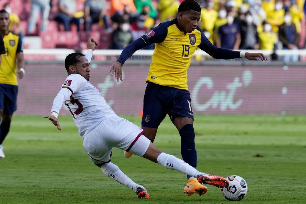 Gonzalo Plaza, de Ecuador, intenta ante José Martínez, de Venezuela, en un partido de las eliminatorias sudamericanas. (AP)