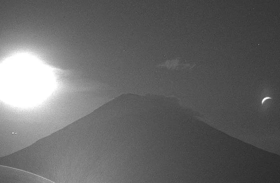 Captura del momento en el que la luna se asoma al volcán popocatepetl.