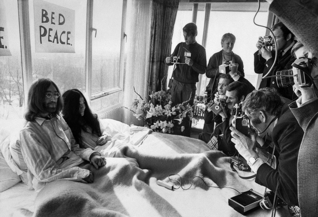 El miembro de los Beatles John Lennon (L) y su esposa Yoko Ono reciben a los periodistas el 25 de marzo de 1969 en el dormitorio del hotel Hilton en Amsterdam, durante su luna de miel en Europa.