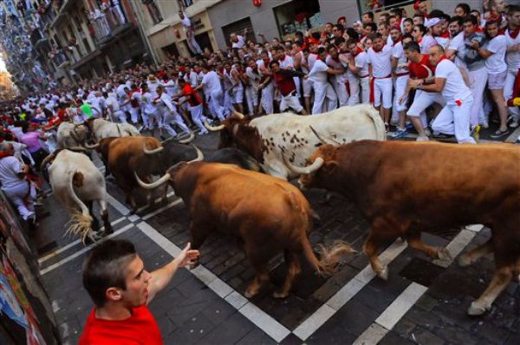 Juerguistas huyen de un toro en una de las corridas por el festival de San Fermín, en Pamplona, España, el domingo 7 de julio de 2013. (Foto AP/Alvaro Barrientos)