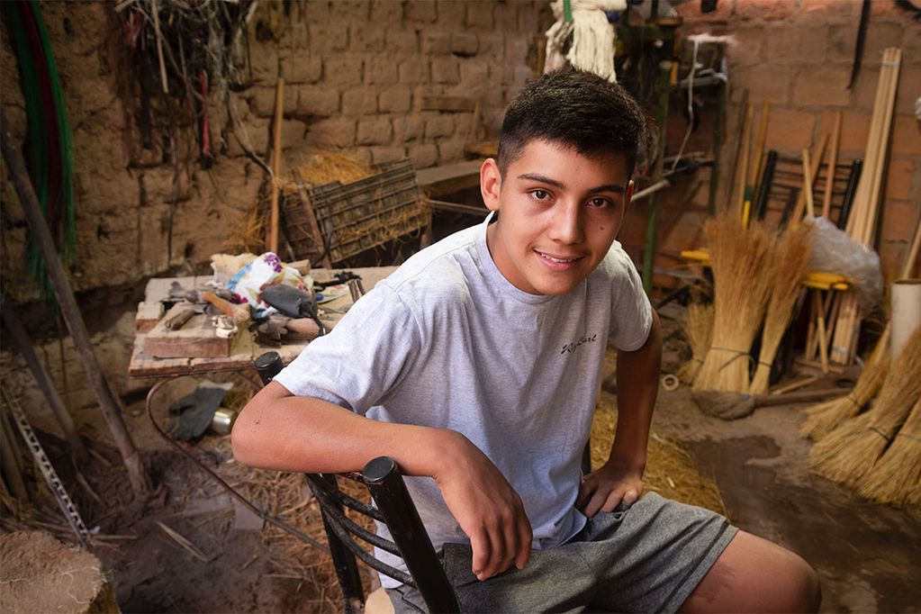 Además de ser un excelente alumno de secundaria, Esteban Brizuela vende las escobas que fabrica con su abuelo. Foto: Ignacio Blanco / Los Andes 