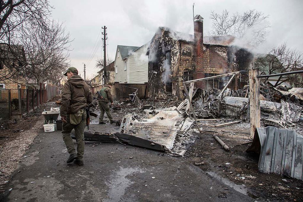 Militares ucranianos caminan frente a los fragmentos de un avión derribado visto en Kiev. (AP Photo)