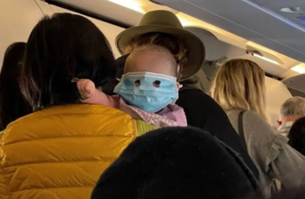 Bebé con barbijo a bordo de un avión.