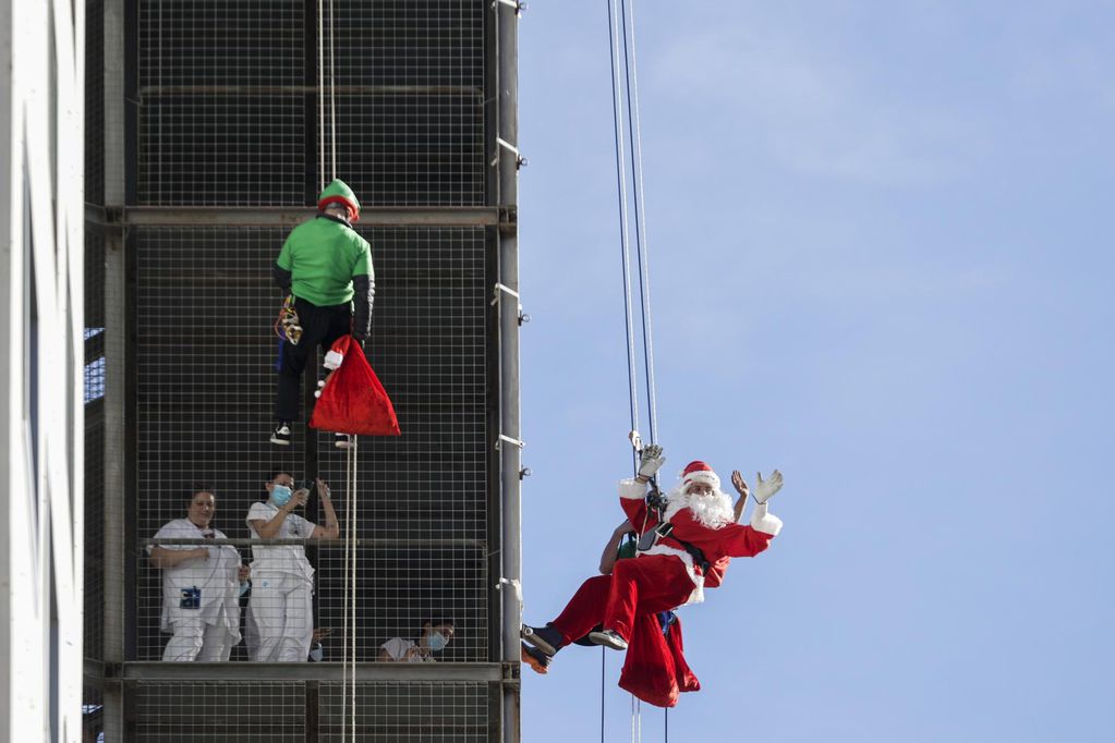 El Papa Noel hizo esta mañana durante el tradicional descenso por la fachada hospital infantil Vall d,Hebrón para llevar regalos a los niños ingresados. Foto: EFE/Quique García