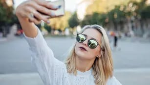 Young woman is taking a selfie by mobile phone.