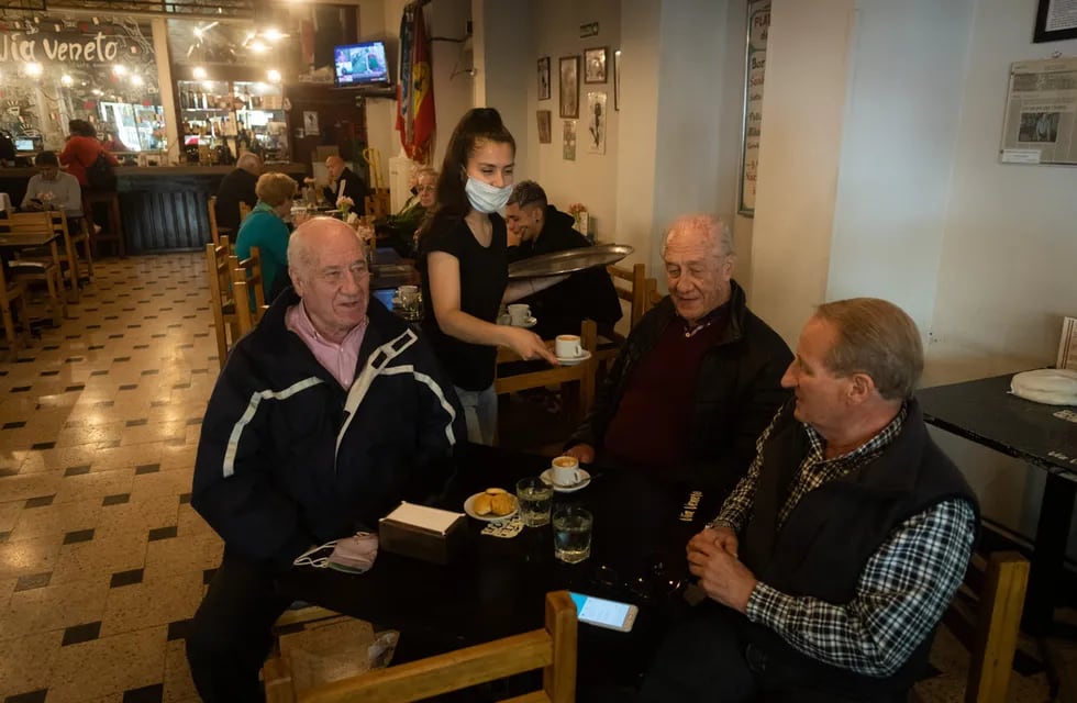 Milagros Yasiulewicz sirve café a Guillermo, Horacio y Rafael. Vía Venetto. Foto Ignacio Blanco / Los Andes
