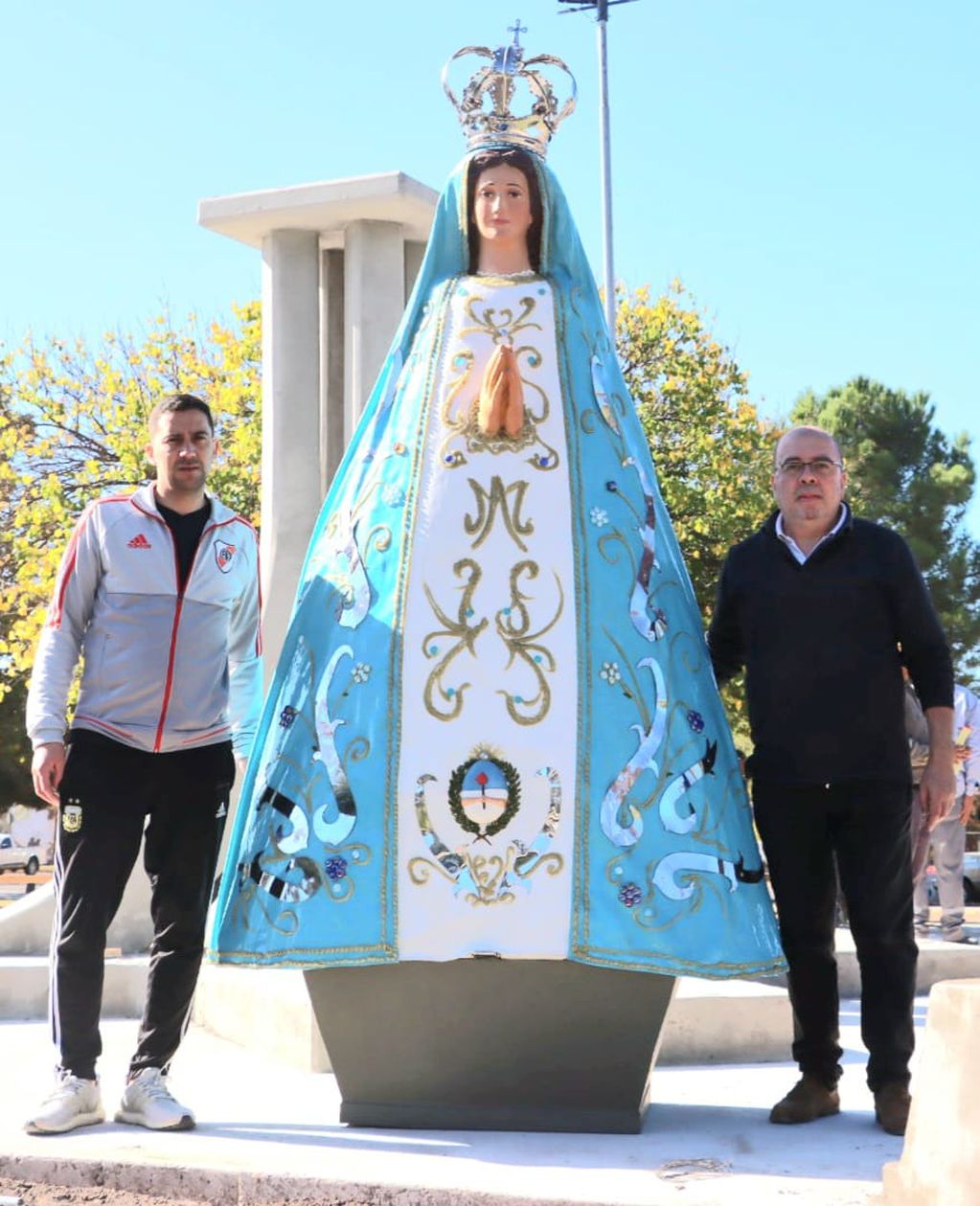 Jonathan Muñoz (a la izquierda), ayudante de Humberto Capella, el escultor (a la derecha). Ambos posan con la imagen de la Virgen que se emplazó en la rotonda de acceso Oeste a Luján de Cuyo.