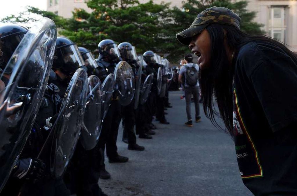 
AFP | Un manifestante grita frente a una fila de policías.
   