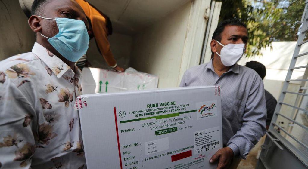 Trabajadores de salud trasladan una caja que contiene la vacuna CoviShield. (AP)