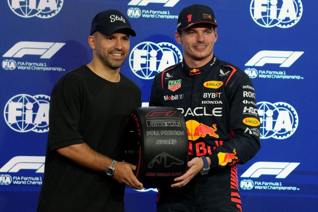 "Kun" Agüero le entrega a Max Verstappen la distinción por haber ganado la pole en la clasificación de la F1 en Abu Dhabi. (AP)