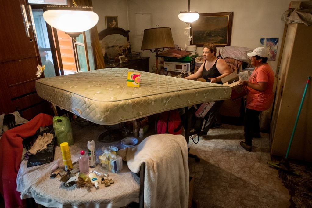 Todo vale para recuperar: Nerina y María, subieron los colchones a la mesa para evitar que se mojen con el agua que se acumuló en el suelo de su vivienda.
