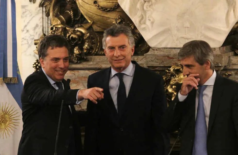 El presidente Mauricio Macri, rodeado por el ministro de Hacienda, Nicolás Dujovne, y el de Finanzas, Luis Caputo.