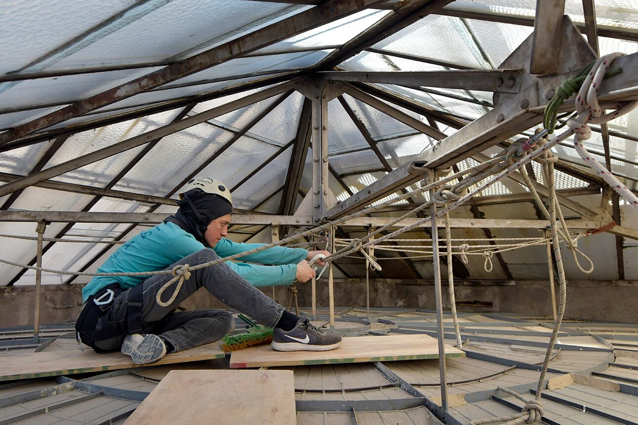El restaurador Carlos Alvacete, trabaja entre la malla protectora y la parte superior de la bóveda. Foto: Orlando Pelichotti