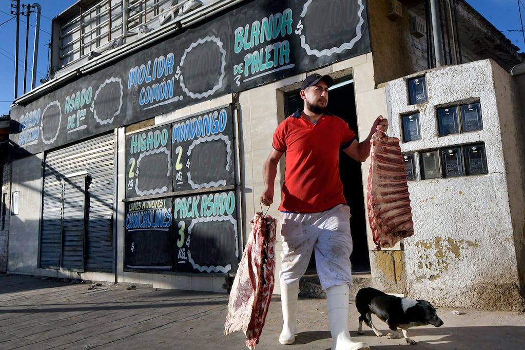 El día después de los saqueos en Las Heras, un empleado de la Carnicería Mignani saca restos de carnes para tirarlas. Las pérdidas fueron totales. Foto: Orlando Pelichotti 
