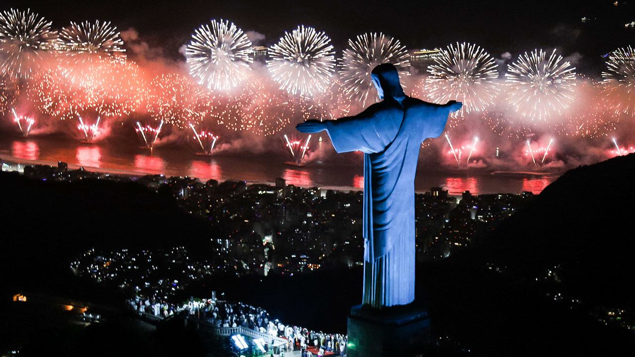 El Cristo Redentor iluminado por los fuegos artificiales en la Playa de Copacabana durante la celebración de Año Nuevo, en Río de Janeiro (Brasil). EFE/ Fernando Maia