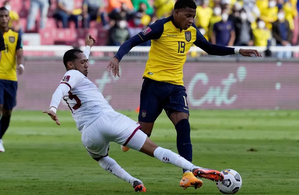 Gonzalo Plaza, de Ecuador, intenta ante José Martínez, de Venezuela, en un partido de las eliminatorias sudamericanas. (AP)