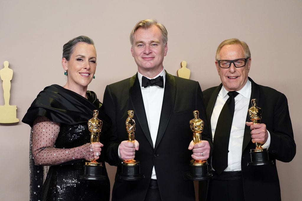 Emma Thomas, de izquierda a derecha, Christopher Nolan y Charles Roven posan en la sala de prensa con el premio a la mejor película por "Oppenheimer" en los Oscar el domingo 10 de marzo de 2024 en el Dolby Theatre de Los Ángeles. (Foto de Jordan Strauss/Invision/AP)