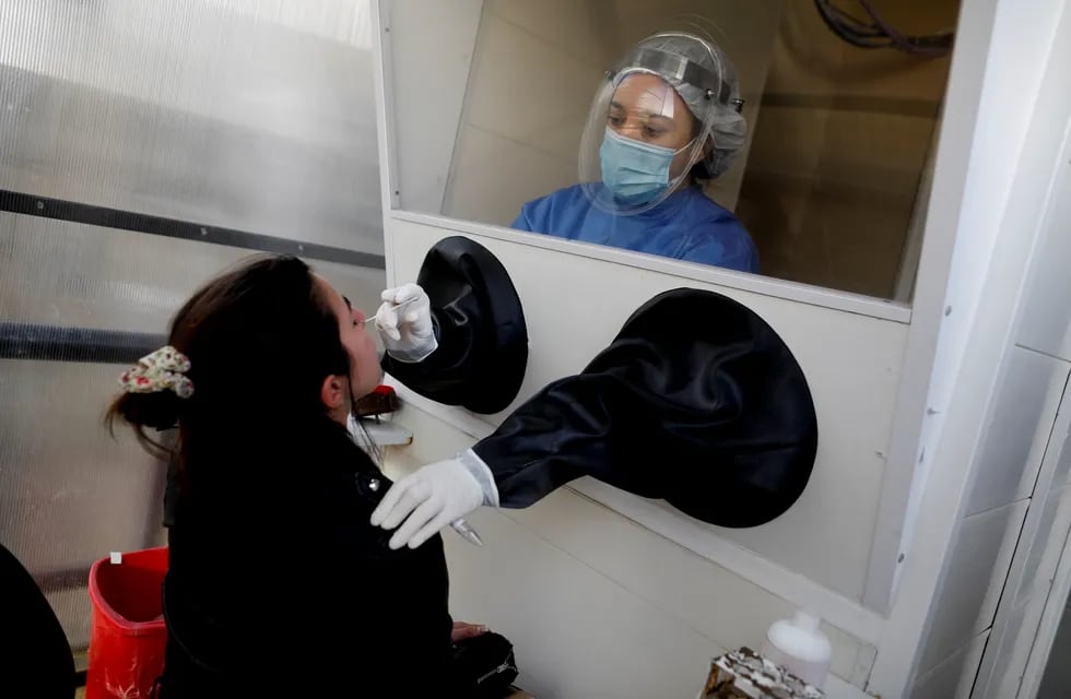Una trabajadora de salud le hace el hisopado a una persona sospechosa de Covid-19 en el hospital Posadas de Buenos Aires. AP