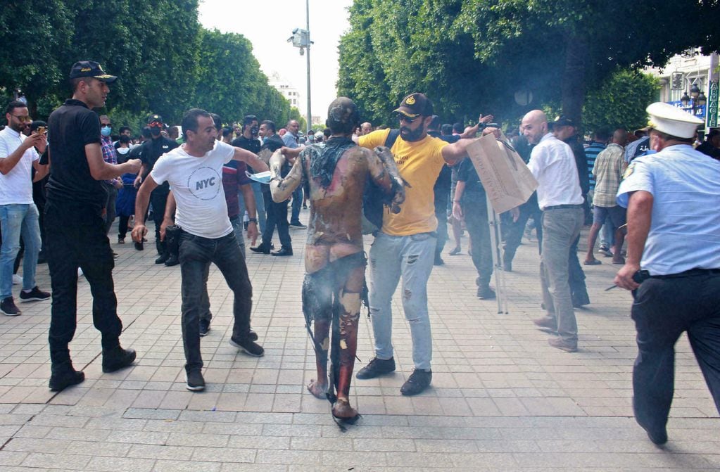Varios peatones intentan ayudar a un hombre, después de que este se prendiera fuego, en el centro de Túnez. Gentileza / rfi