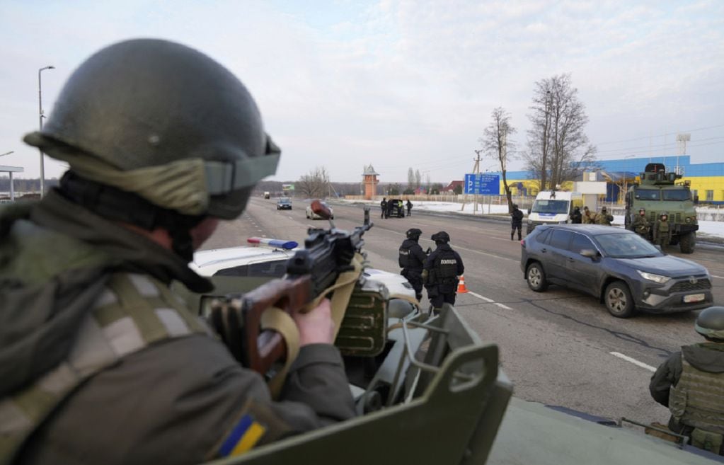 Un soldado de la Guardia Nacional de Ucrania, a la izquierda, sostiene su arma lista mientras protege el puesto de control móvil con agentes del Servicio de Seguridad de Ucrania y policías en Kharkiv, Ucrania. (AP)