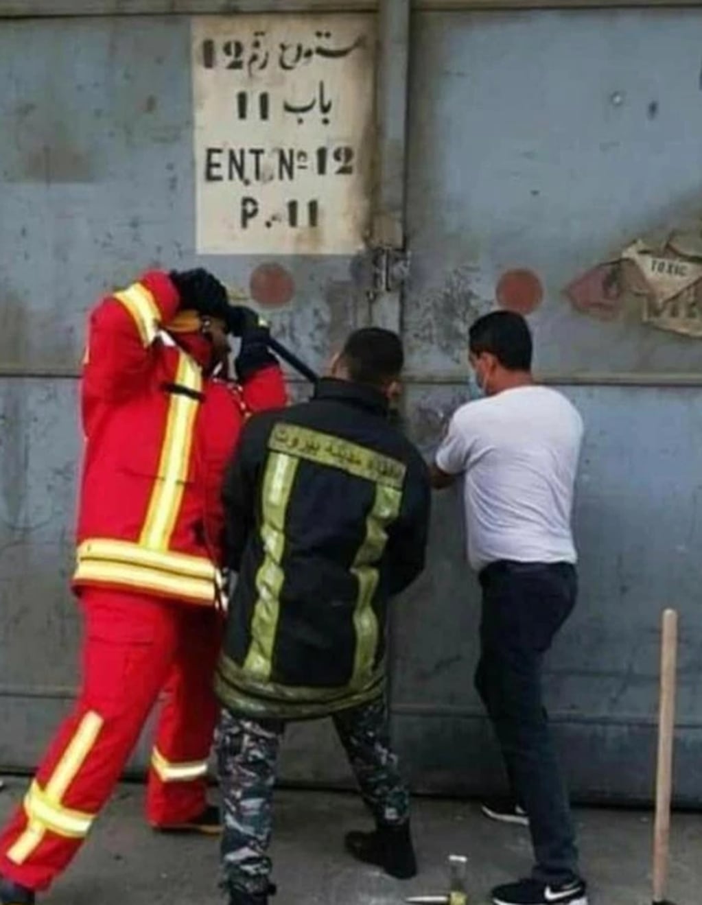 Un grupo de bomberos intenta abrir el almacén de la tragedia. La persona que tomó la foto murió y el resto está desaparecida.